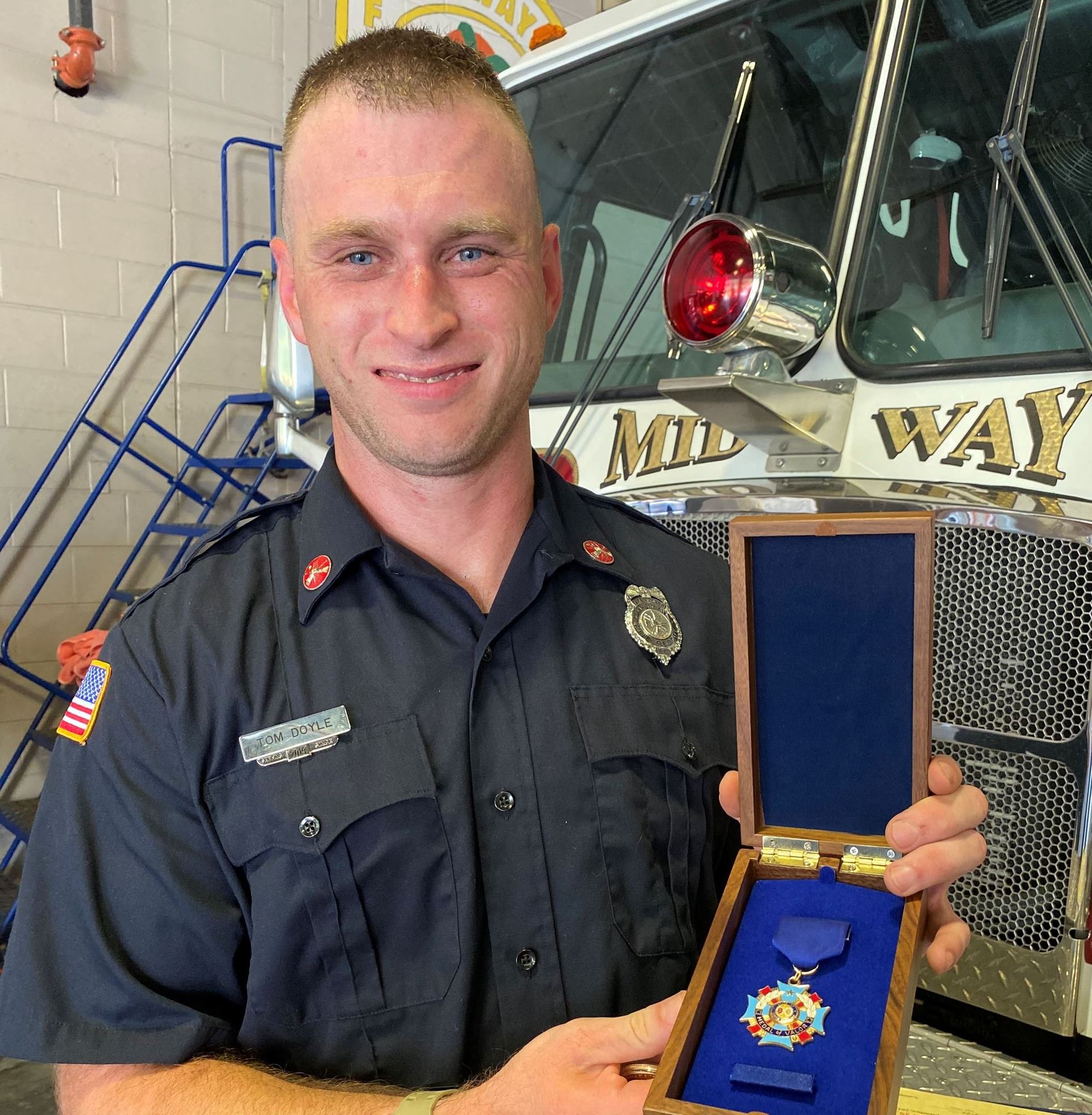 Thomas Doyle holds up the Medal of Valor.