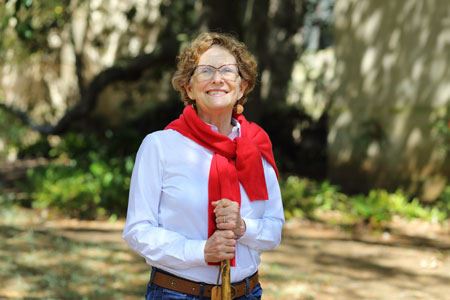 Portrait of Ann Humphries standing outdoors holding a book