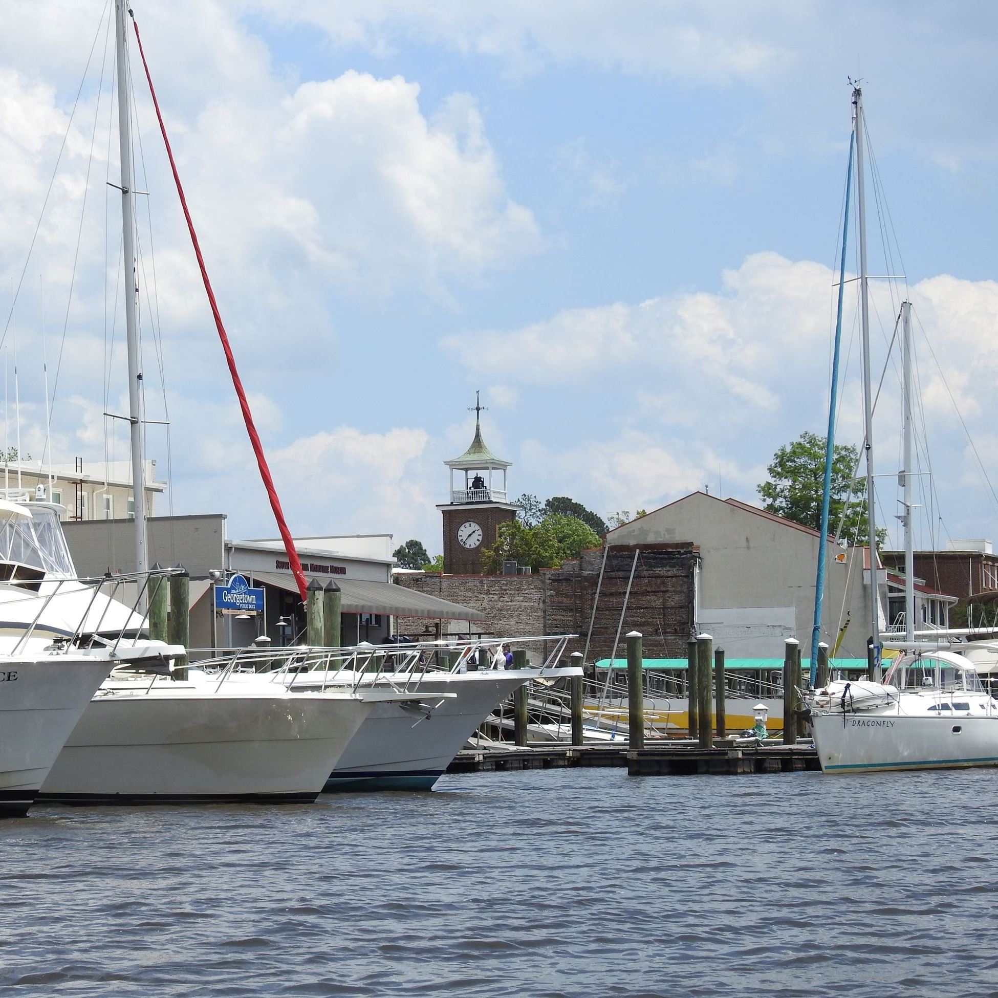 Boats docked along the Georgetown Harbor with the clocktower in the background.