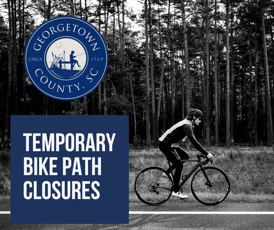 Black and White Photo of person biking along a paved path