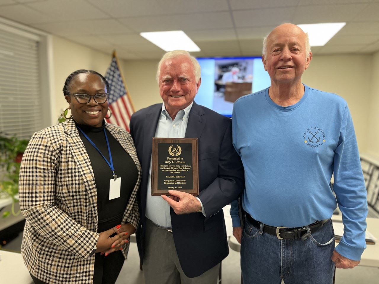 Billy Altman is pictured holding a plaque with Aphra McCrea and James Sanderson