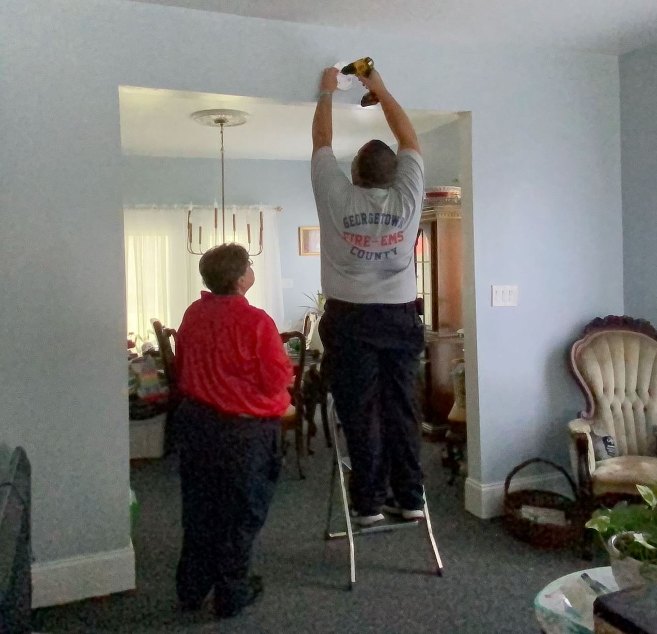 Firefighters installing a smoke detector in a home.