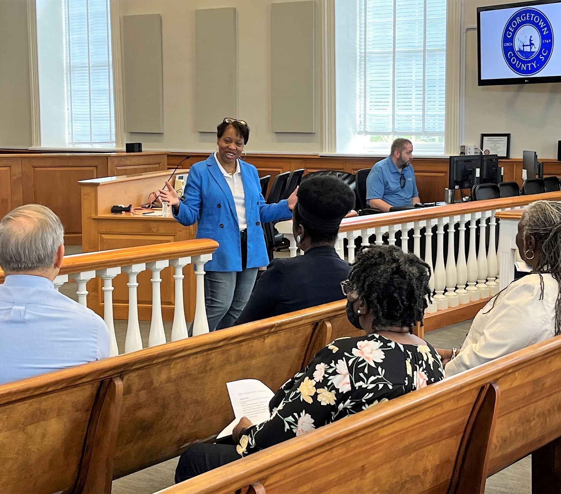 The County Administrator talks to a small group of people in Council Chambers