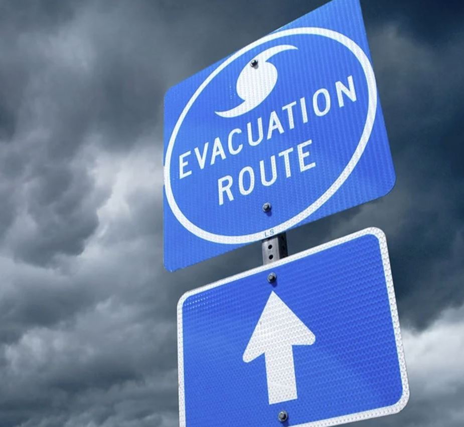Image of a hurricane evacuation route sign with a stormy sky in the background