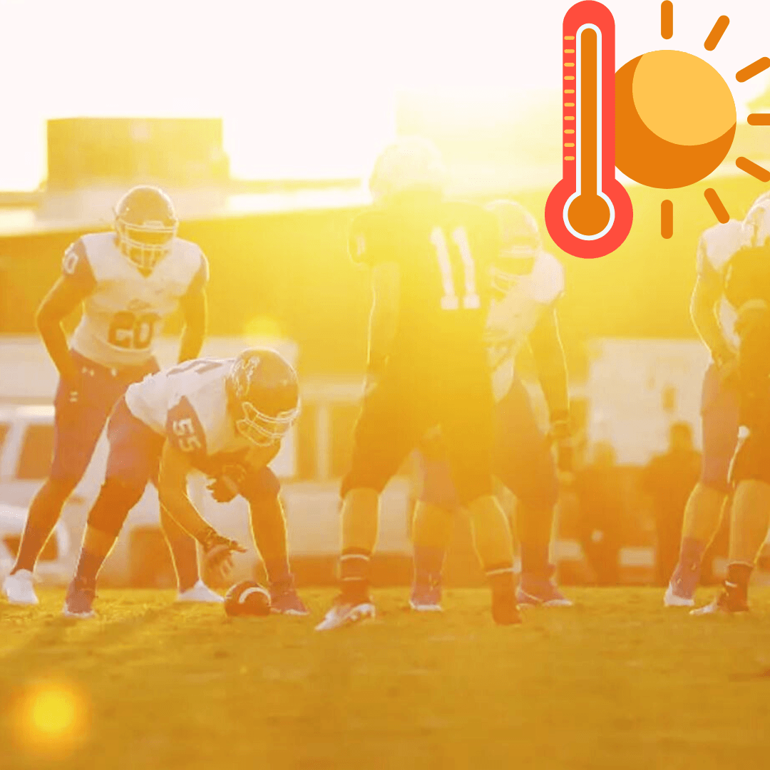 Football players on a field backlight by a blazing sun