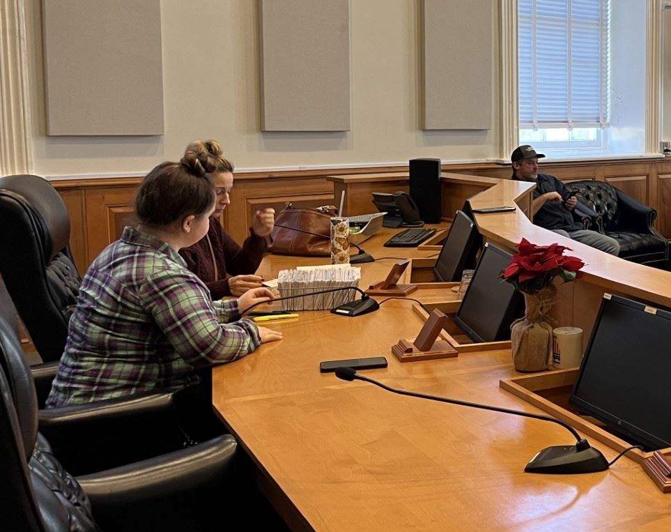 Staff members look through files at the desks normally used by County Council