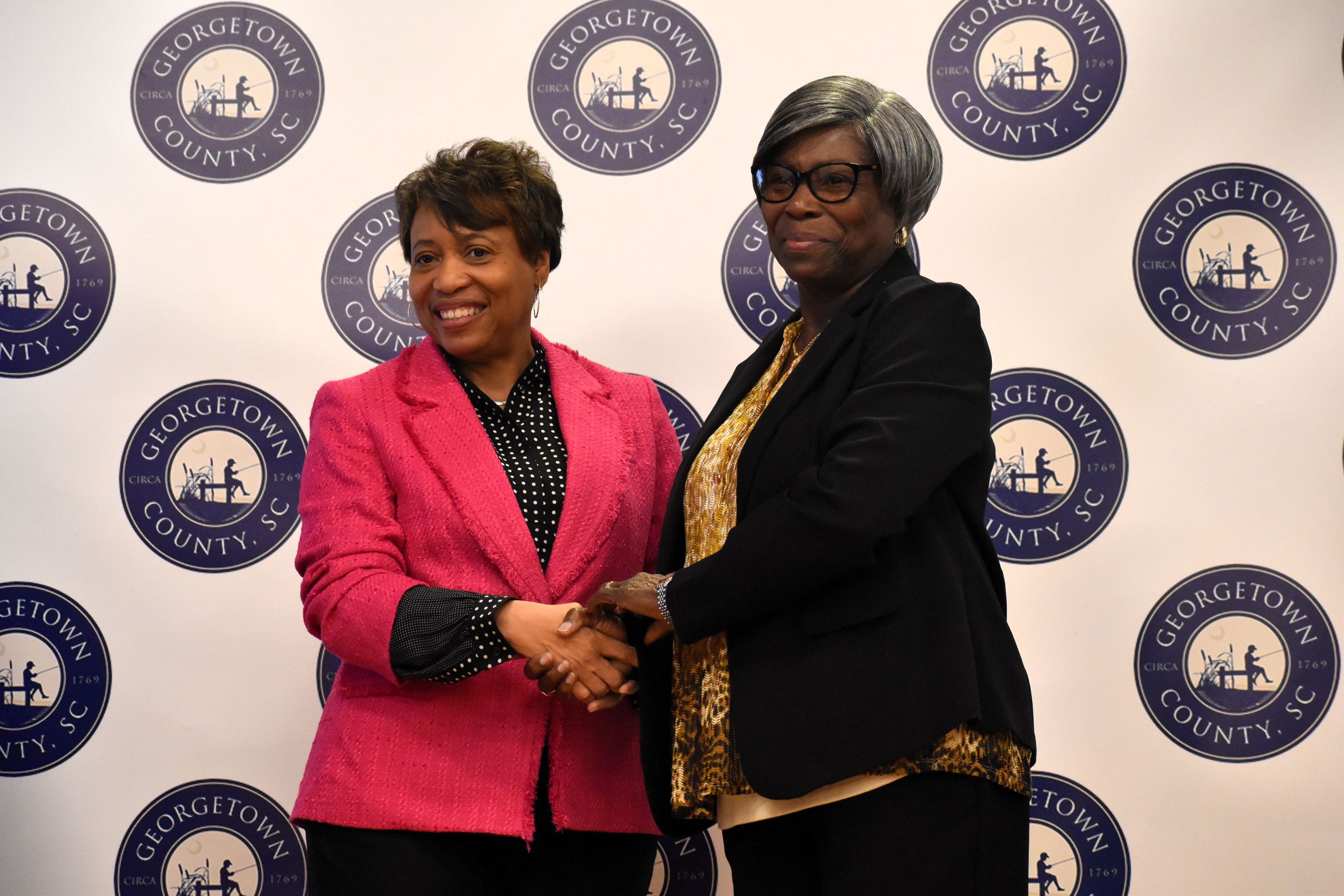 Betty Bowens, right, shakes hands with County Administrator Angela Christian.