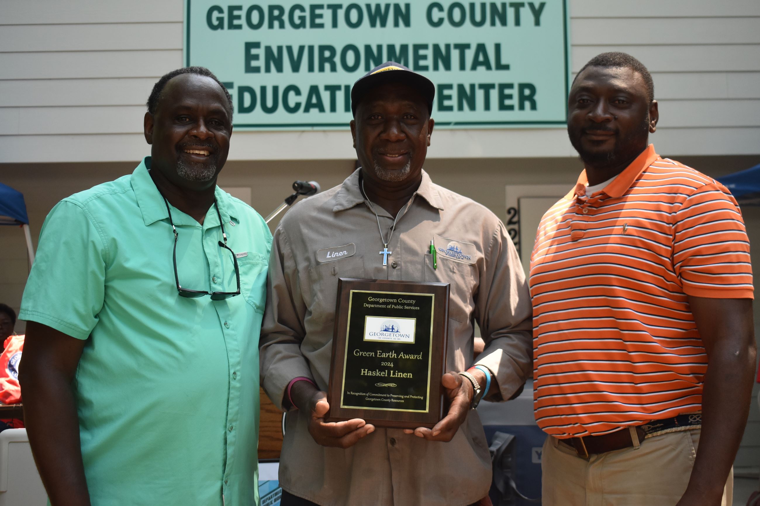 Ray Funnye, Haskel Linen and Jacob Nesmith stand in front of the Environmental Education Building.