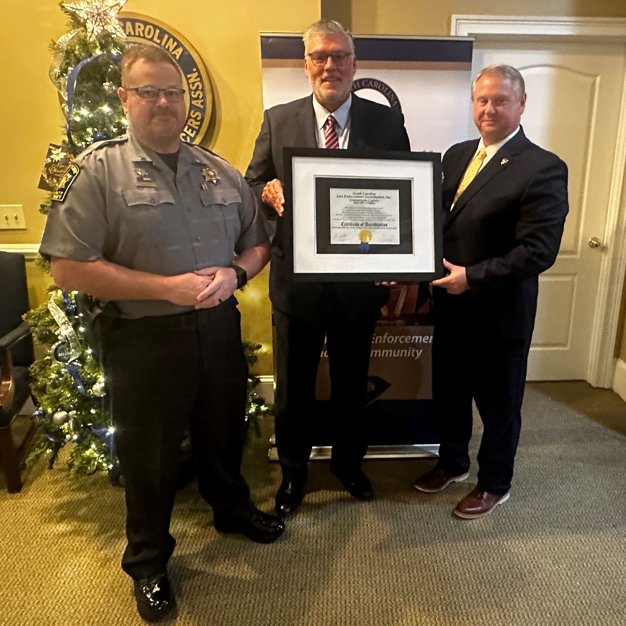 Sheriff Carter Weaver (center) and Lt. Chris Geno accept their reaccreditation certificate 