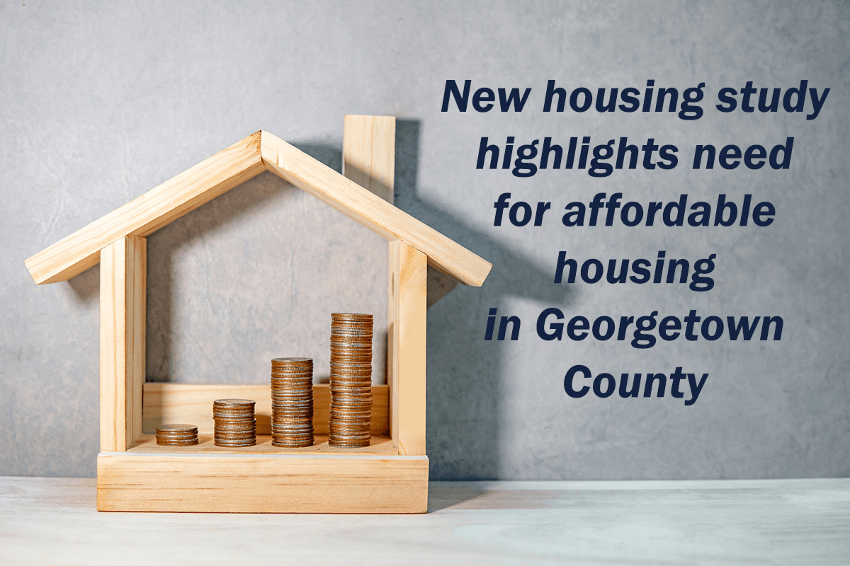 Image of a small wooden frame in the shape of a house with coins stacked inside.