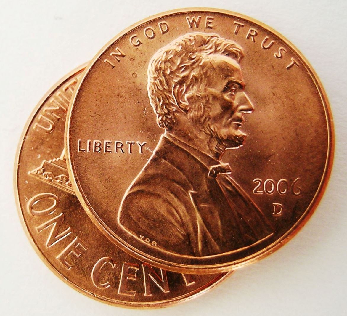 two pennies overlapping on a white background